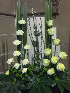 white flowers and greenery in a black pot