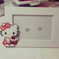 an image of a hello kitty in a frame on the counter with other items behind it