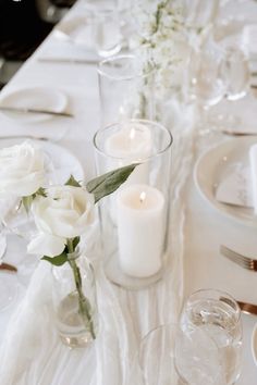 the table is set with white flowers and candles