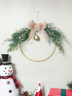 a christmas wreath with a snowman, pine cones and a bell hanging on the wall