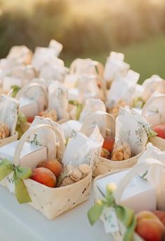 small baskets filled with different types of food on a white table cloth covered tablecloth