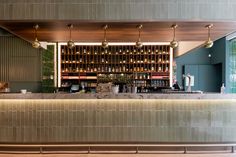 an empty bar with lots of bottles on the wall and lights hanging from the ceiling