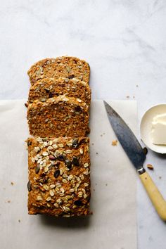 a loaf of bread sitting on top of a cutting board next to a knife and spoon