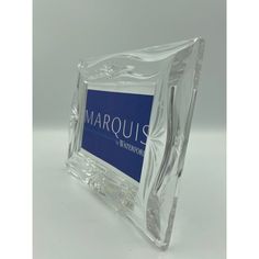 a clear glass block with the marques logo on it's front and side