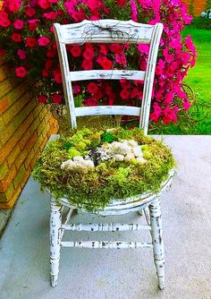 a white chair with moss and flowers on it