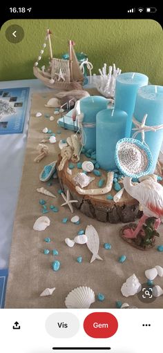 a table topped with blue candles and seashells