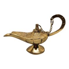 a golden metal bird shaped object with a chain hanging from it's back end