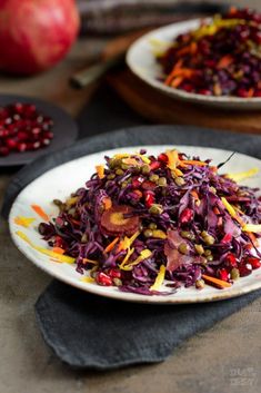 a white plate topped with red cabbage and pomegranate