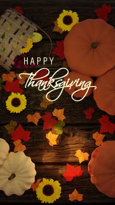 a thanksgiving card with pumpkins and fall leaves on a wooden surface, the words happy thanksgiving written in white