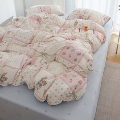 an unmade bed with many pillows on it