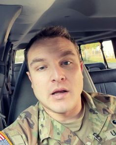 a man in uniform sitting in the back seat of a car