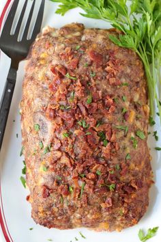 a white plate topped with meat covered in sauce and garnished with parsley