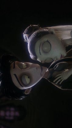 two animated dolls in the dark with their mouths open and eyes closed, looking at each other