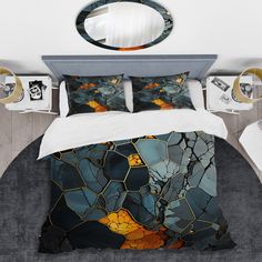 a bed with an artistic design on the comforter and pillow cases, along with other decorative items