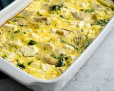 a casserole dish with chicken, spinach and cheese in it on a table