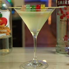 a martini with gummy bears on the rim