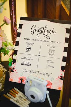 there is a sign that says guestbook and some pencils on the table next to it