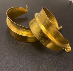 A simple but striking piece of African handmade statement cuff bangle in brass gold that completes gives an edge to your style. Handmade in Mali, West Africa inspired by jewellery worn by the Fulani women to display their wealth and nobility.  Find the gold earrings here https://www.etsy.com/uk/listing/1109194210/fulani-earrings?click_key=ea7e7038731be9c3943107952dfd5b6f66cb2f71%3A1109194210&click_sum=0344547d&ga_search_query=Gold&ref=shop_items_search_2&crt=1 Find the gold necklace here Africa Jewelry, Gold Cuff Bangle, Fulani Earrings, Hand Candy, Exotic Jewelry, Handmade African, Gold Cuffs, African Jewelry, Brass Gold