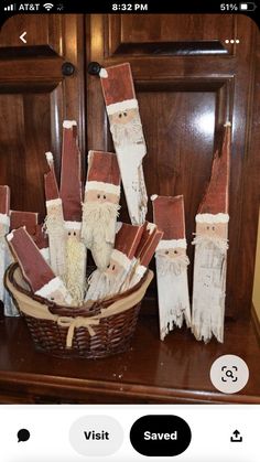 a basket filled with wooden santas sitting on top of a table