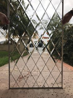 the reflection of someone's hand on a mirrored door in front of a house