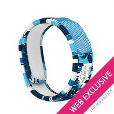 a bracelet with blue and white designs on the inside, in front of a pink ribbon