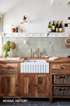 a kitchen with wooden cabinets and white tile backsplash, wine bottles on the wall