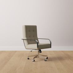 an office chair sitting on top of a hard wood floor next to a white wall