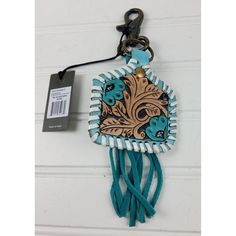 a keychain hanging from the side of a door with a blue tassel