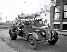 an old black and white photo of a tow truck