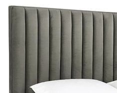 an upholstered headboard with white pillows on it and a pillow in the middle