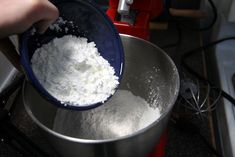 a person mixing flour in a bowl on the stove