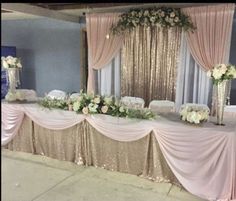 the table is set up with white flowers and gold sequins for an elegant touch