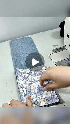 a person is using a sewing machine to sew something on a piece of fabric