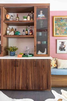 a wooden cabinet sitting in the middle of a living room next to a white dog