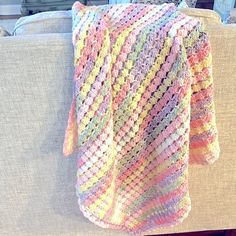 a crocheted blanket sitting on top of a couch