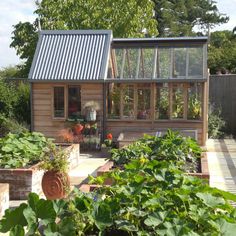 a small wooden house surrounded by lots of plants