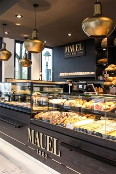 a bakery filled with lots of different types of breads and pastries on display