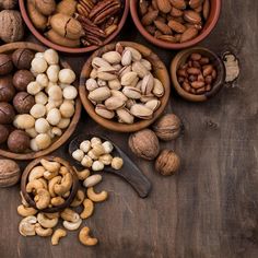 nuts in bowls and spoons on a wooden table