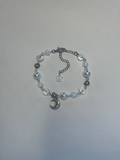 "Handmade silver beaded bracelet with silver moon and heart charms. Made with assorted clear, pearl and white cracked beads. Comes with 2.5inch extender making total length about 9.5\"." Moon Charm Bracelet, Silver Crystal Bracelet With Heart And Round Beads, Silver Crystal Bracelet With Heart Shaped Beads, Silver Bracelets With Moon Charm And Round Beads, Silver Bracelet With Moon Charm And Round Beads, Silver Beaded Bracelets With Moon Charm As Gift, Silver Pearl Charm Crystal Bracelet, Silver Crystal Bracelet With Pearl Charm, Adjustable White Moon Shaped Bracelets