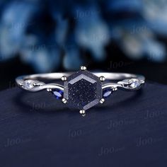 a diamond ring with blue sapphire stones on the side and white diamonds in the middle