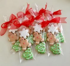 decorated cookies in cellophane bags with red bows and ribbons on white table top