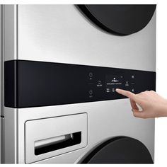 a hand pointing at the control panel on a washing machine that is silver and black