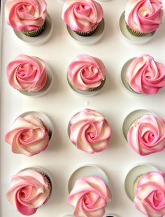 six cupcakes with pink frosting in a white tray