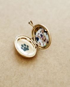 a dog's paw is shown in the reflection of an open locke with a photo inside