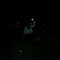 a person standing in the dark holding up a cell phone