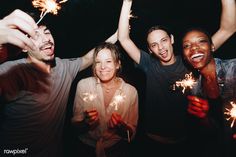 group of people holding sparklers in their hands