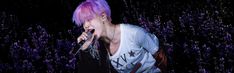 a man with purple hair and piercings on stage