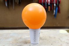 an orange light bulb sitting on top of a table