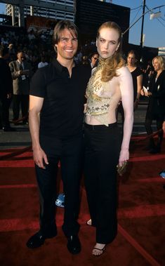 a man standing next to a woman on a red carpet