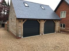 two garages in front of a brick building with blue roof and shingled windows